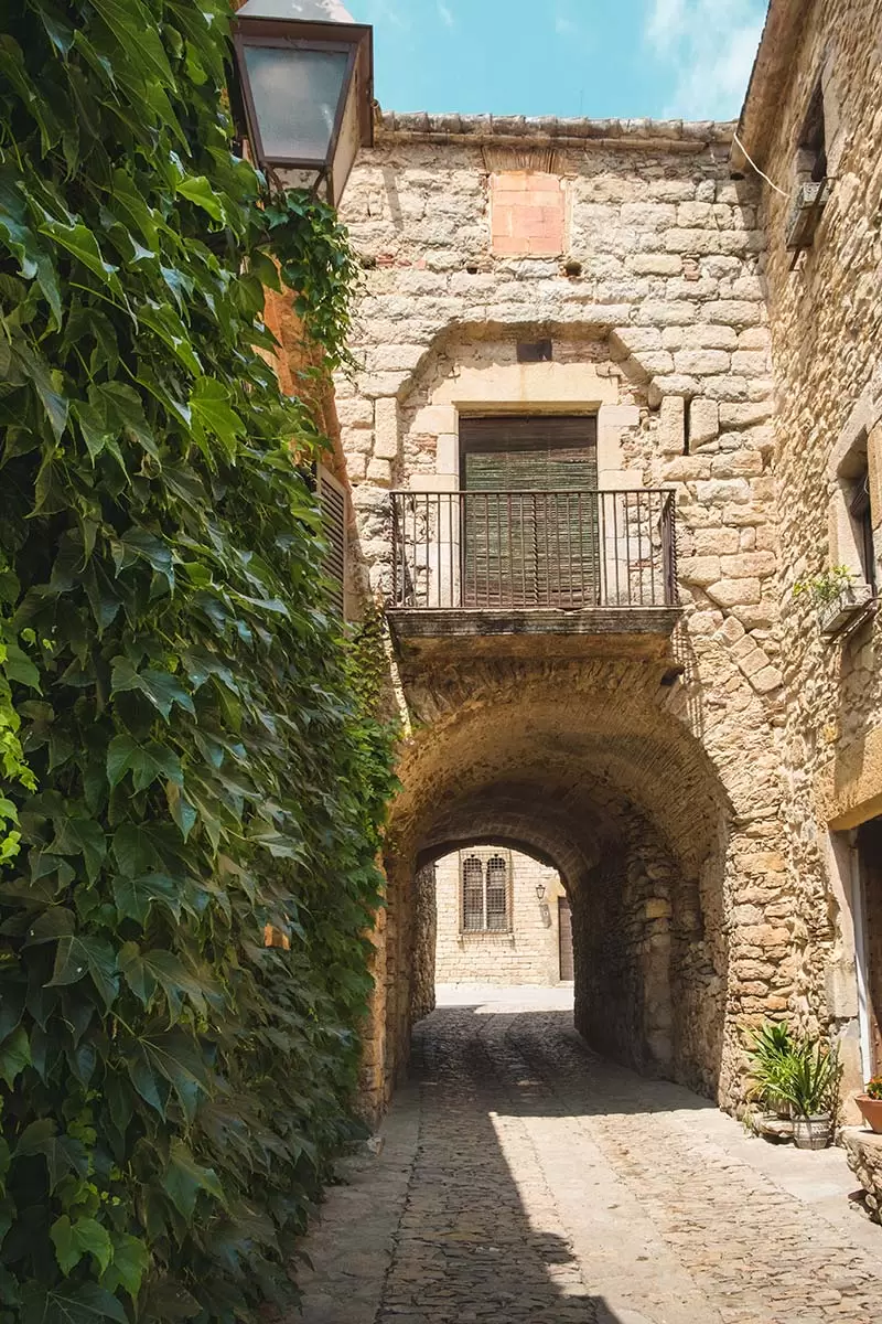 Best things to do in Costa Brava - Peratallada medieval arch flowers