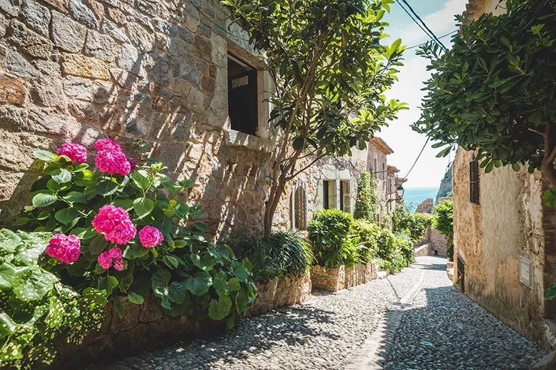 Best things to do in Costa Brava - tossa de mar old town cobblestone alley with flowers