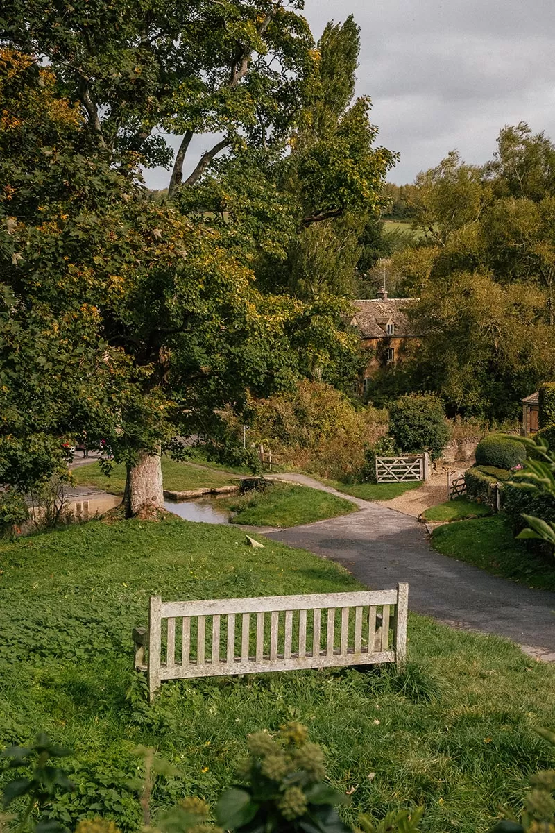 Top things to do in Upper Slaughter -The Cotswolds - Path to River Eye stone bridge and park bench