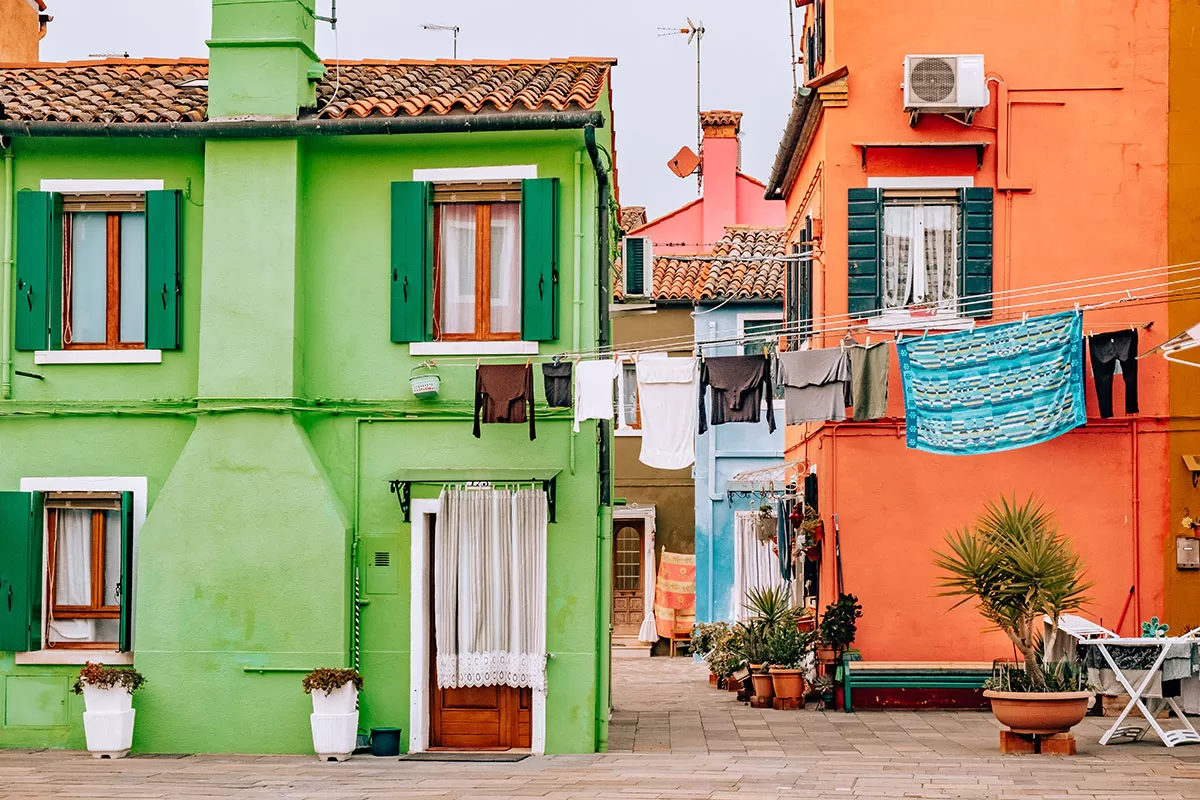 Things to do in Burano Italy - Green and orange house with washing line